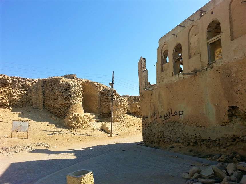 Ruins of the Naderi Fortress in Qeshm, showing ancient Seljuk stone towers and mortar against a desert sky.